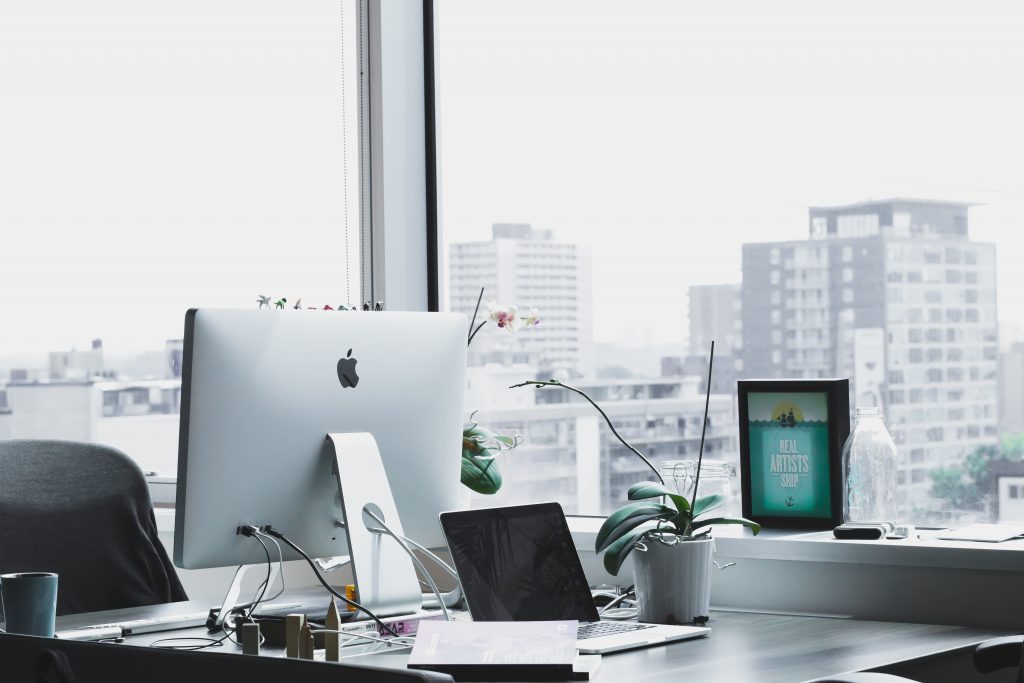 An office environment with a window that provides a view of the city