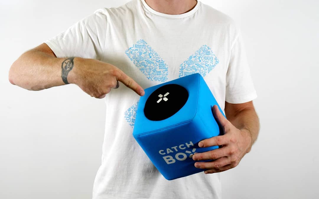 A man holding the Catchbox throwable microphone