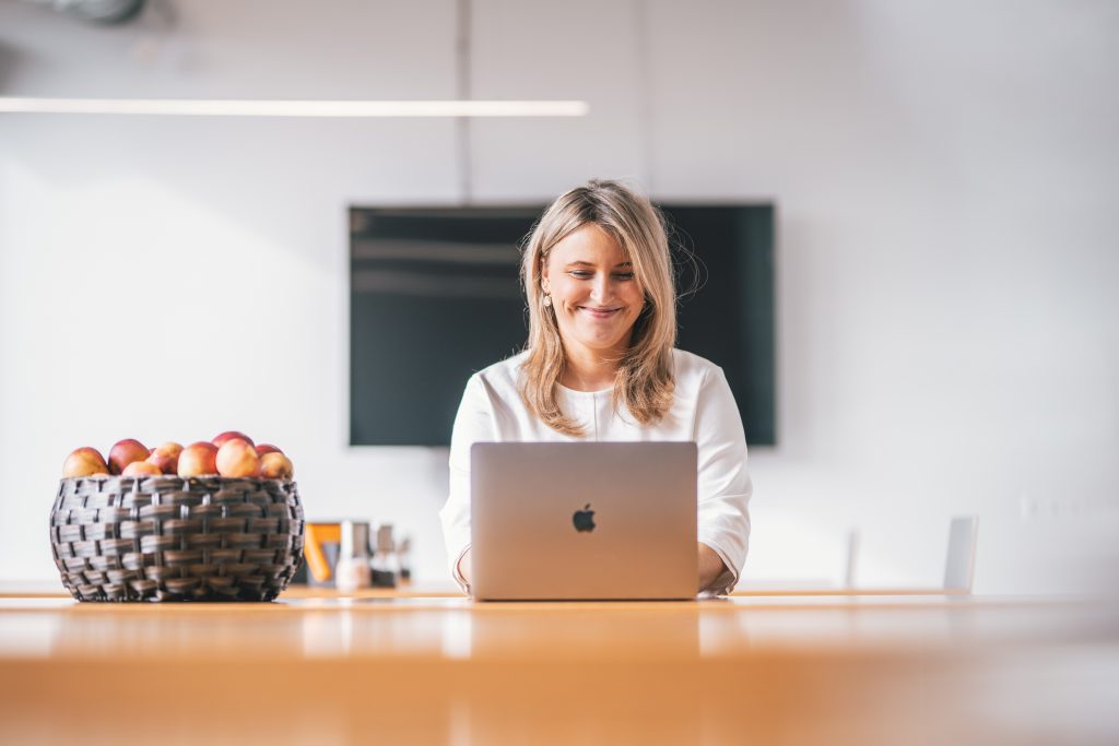 A person smiling while using a laptop