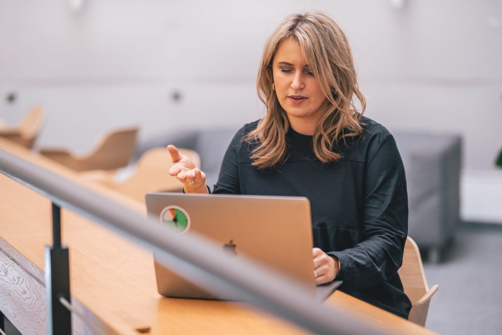 Woman pointing at computer during remote meeting