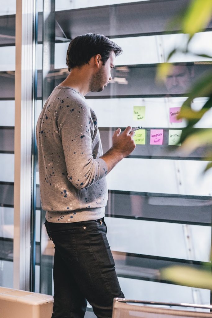 Person writing ideas on a sticky notes