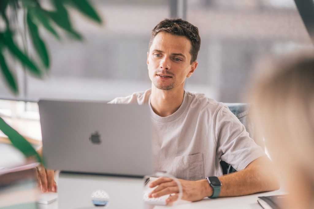 Man hosting a hybrid meeting on his laptop