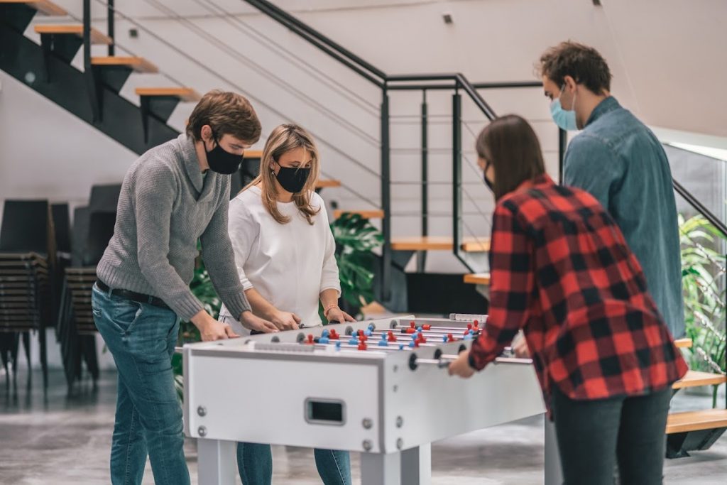 Team playing table football in office