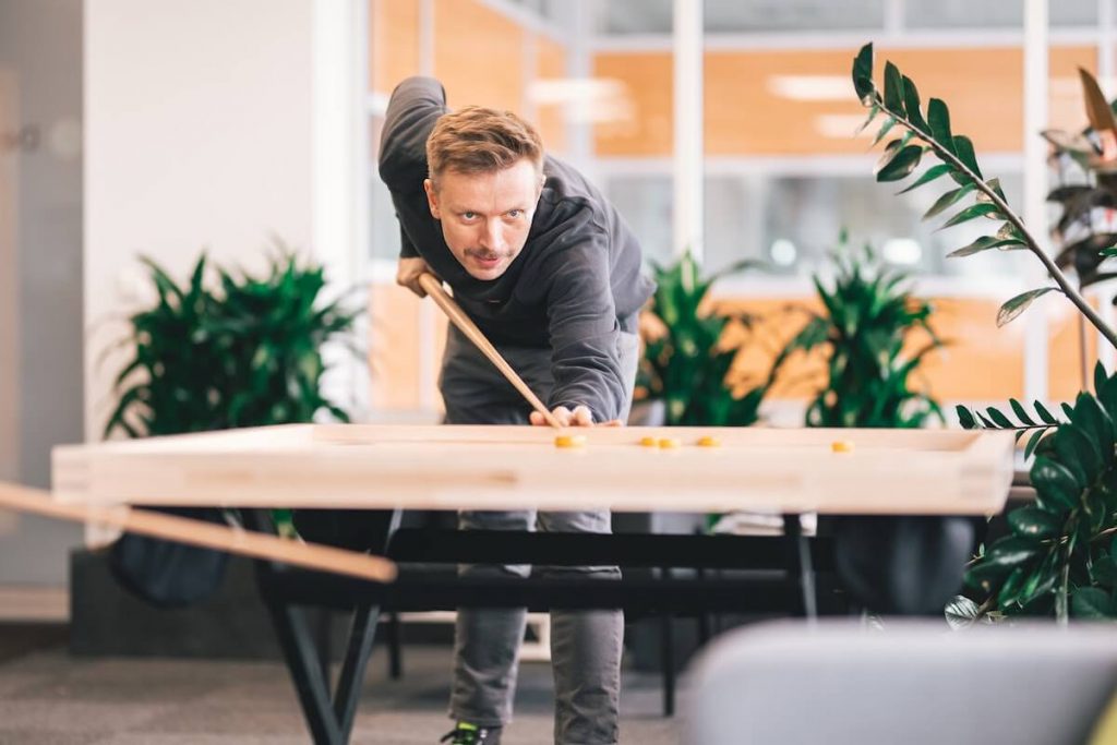 An employee at work relaxing by playing a game in the break room