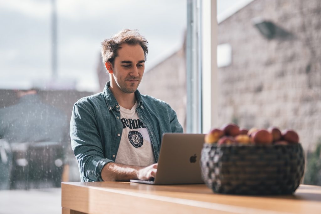 Person smiling while using a laptop