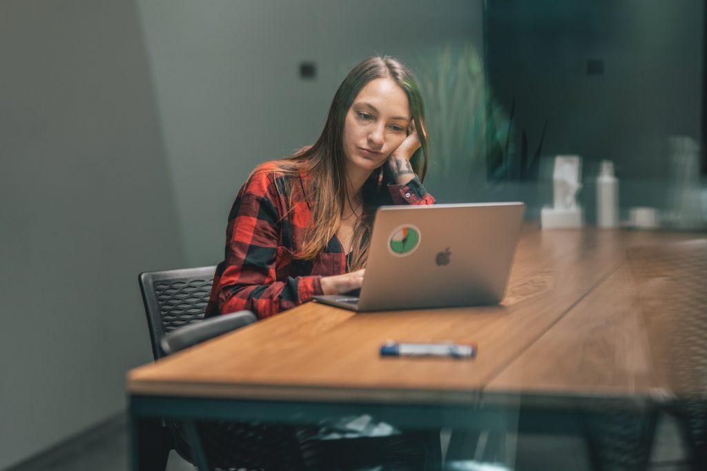 A woman at the laptop using distracting apps