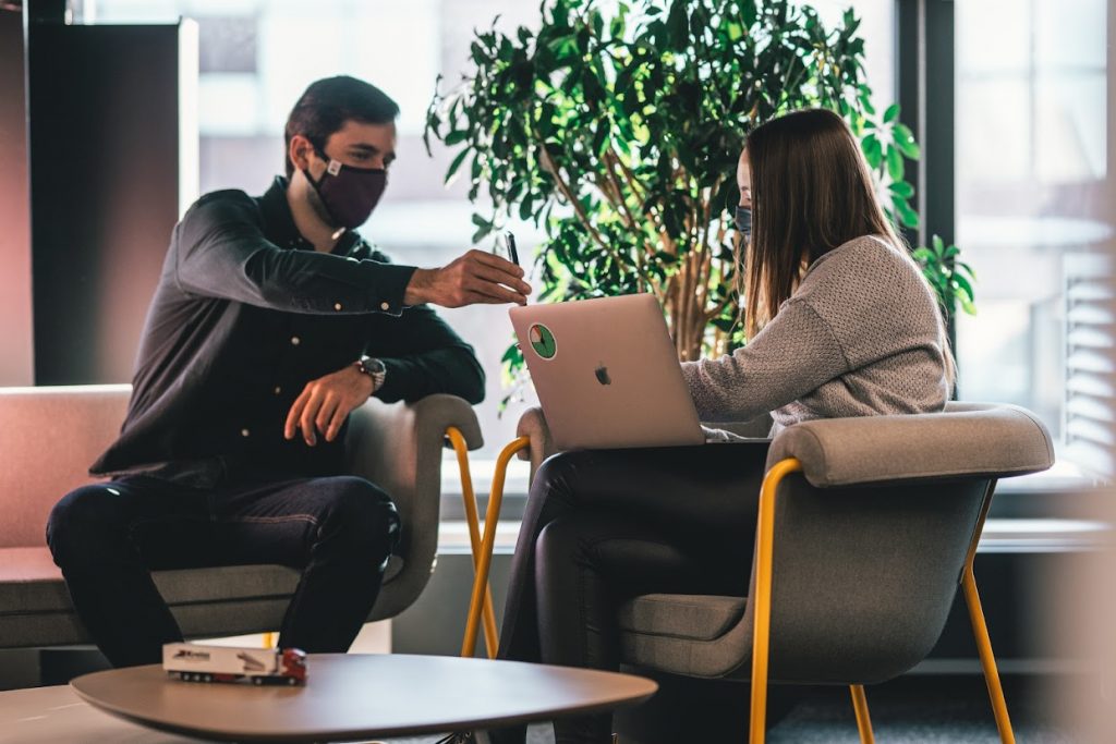 Two people sharing information, wearing masks