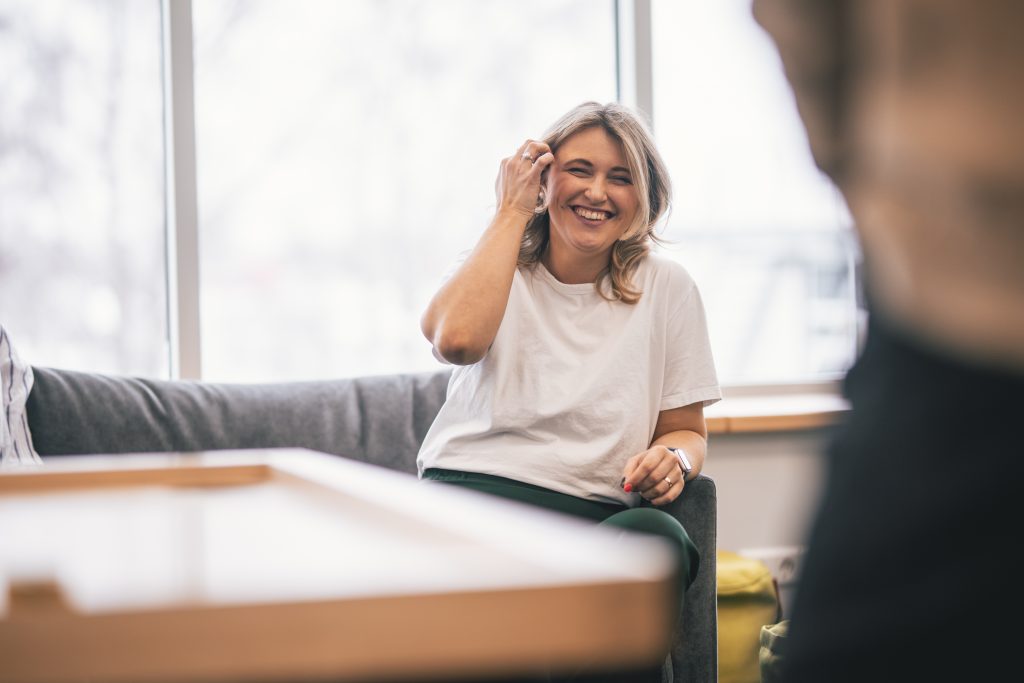 A woman laugihing in a workplace meeting 