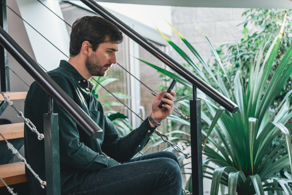 A man using his smartphone while sitting on the stairs