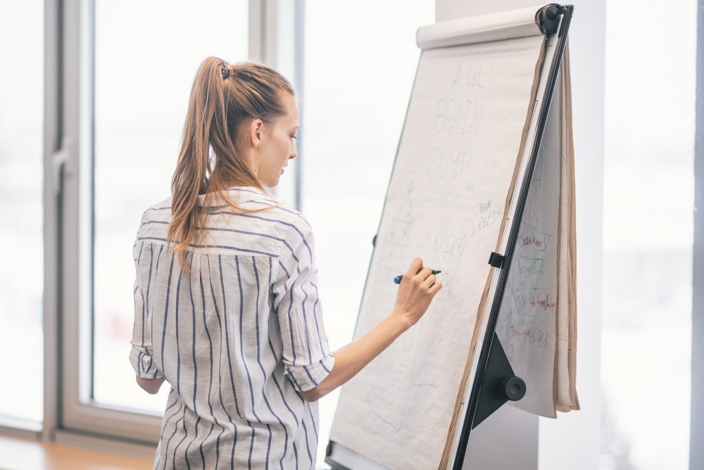 A woman making notes on a whiteboard