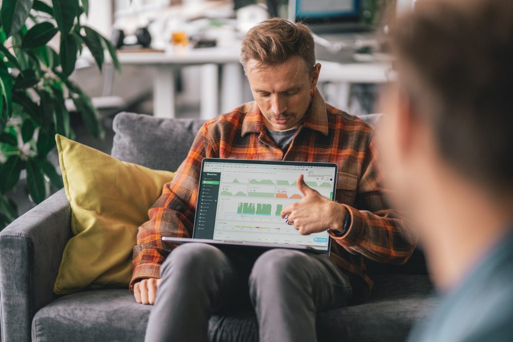 A man showing the benefits of an employee attendance tracker to a team member