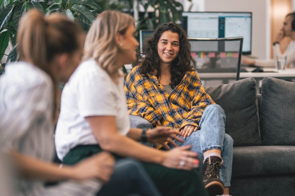 Happy employees are talking at the office after the implementation of the new ways of working framework