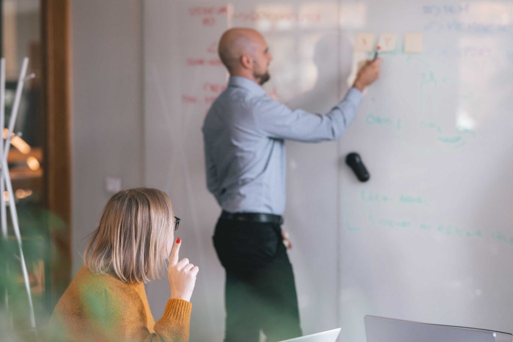 man explaining waterfall project management methodology on whiteboard