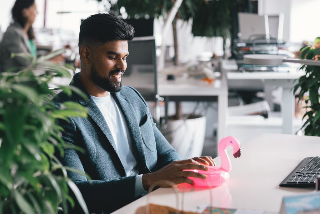 man with an inflatable flamingo making use of tips for transitioning back to the office