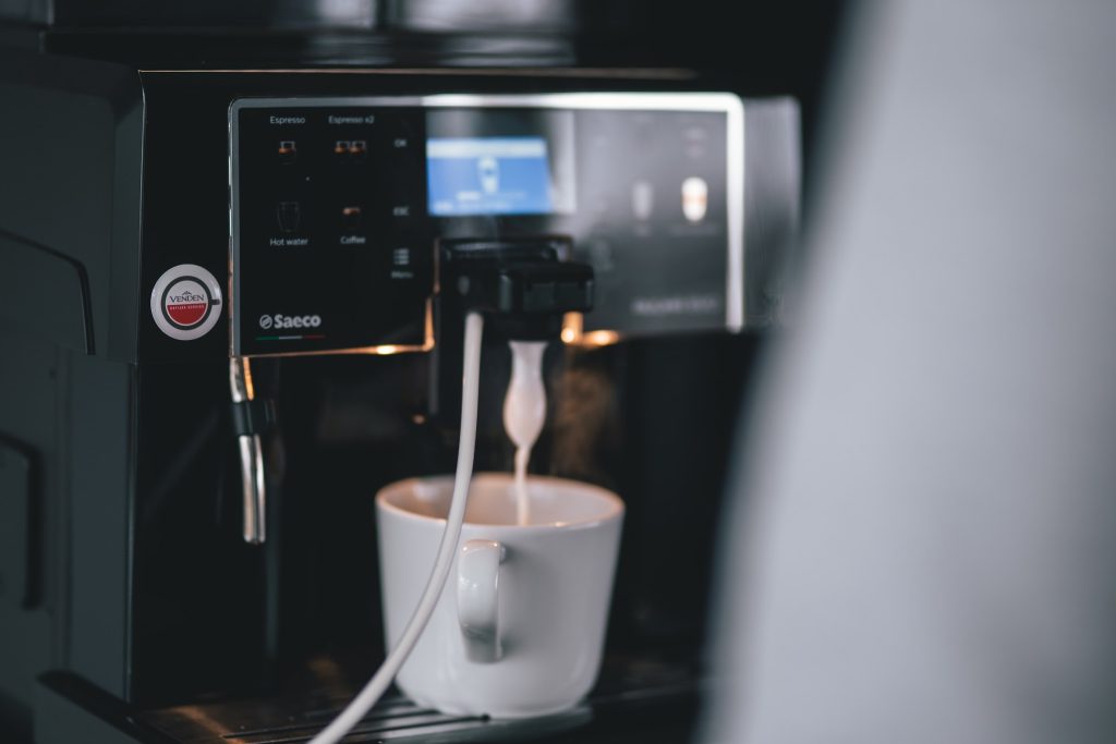 A coffee machine pouring milk