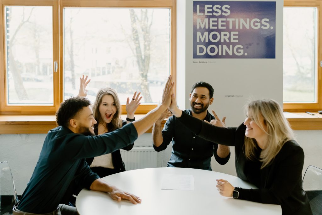 Diverse group of employees high-fiving 