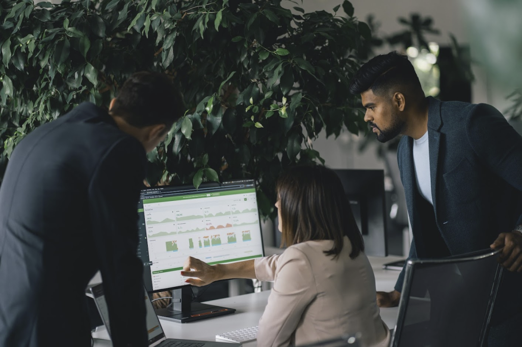 Woman showing two colelagues how to manage productivity in the workplace