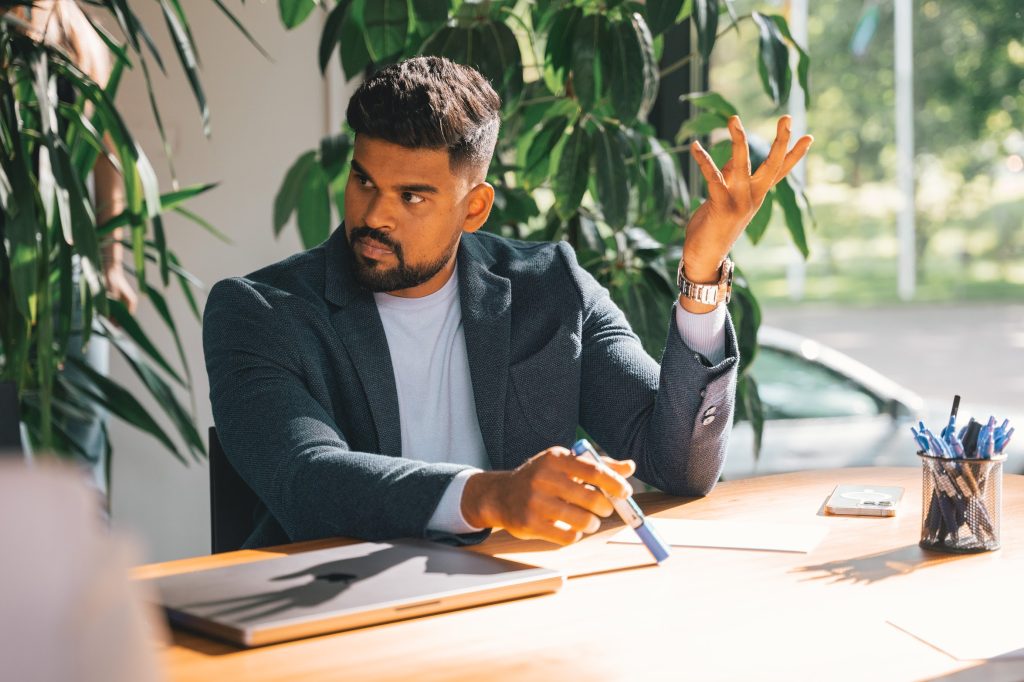 A man sitting at desk asking a question