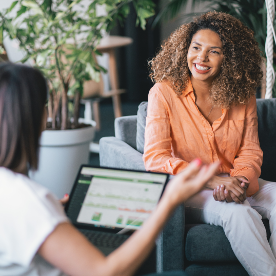 An image of two women talking with one of them in focus.