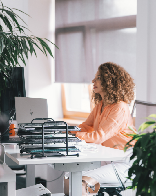 A woman sitting at a desk working on a computer