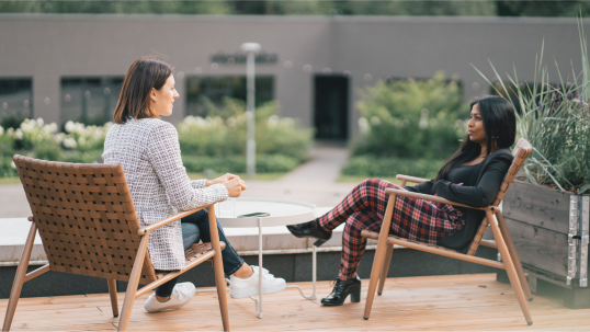 Two women having a conversation while sitting in chairs